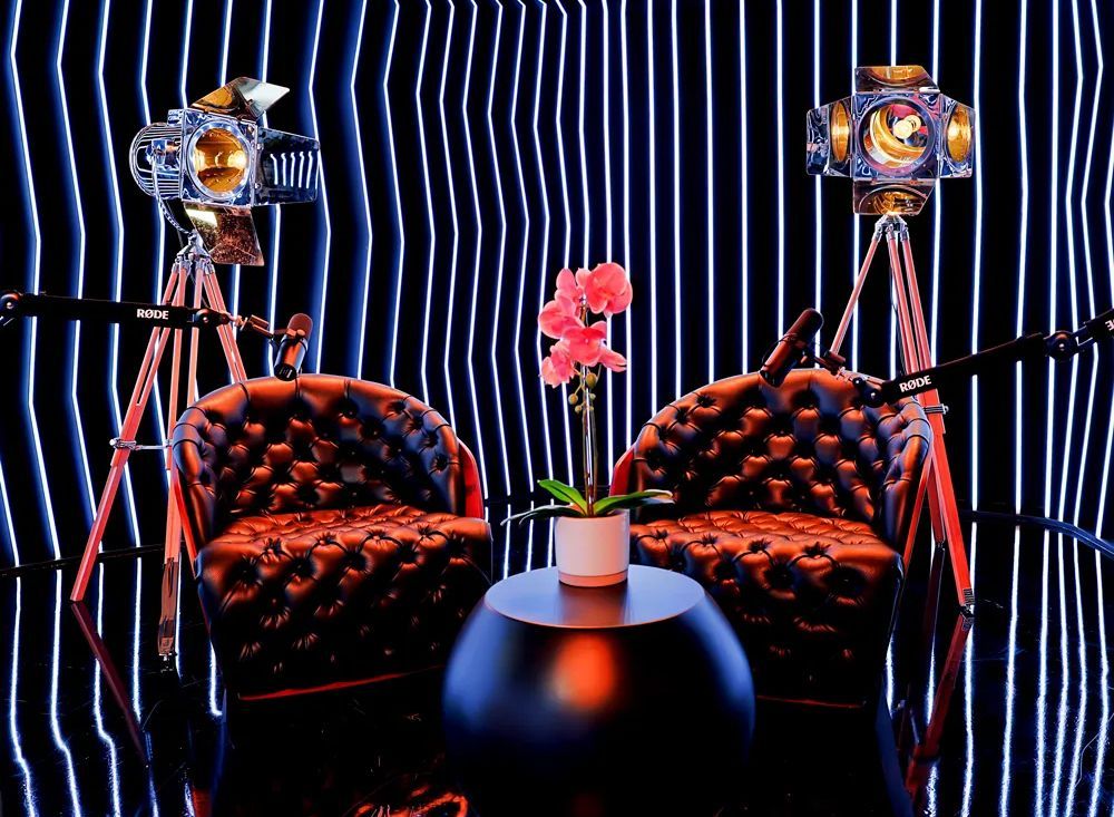 A room with two chairs , a table , and two spotlights.