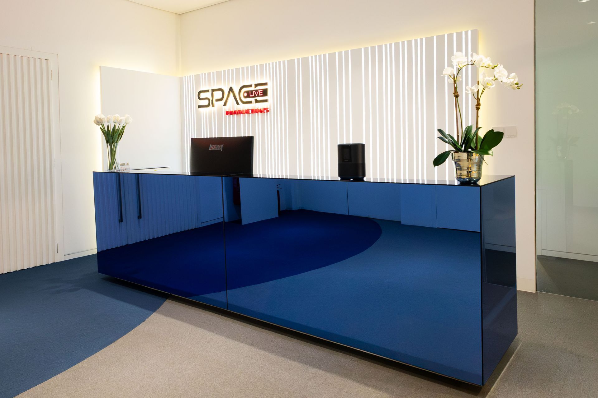 A blue reception desk in a room with a sign that says space.