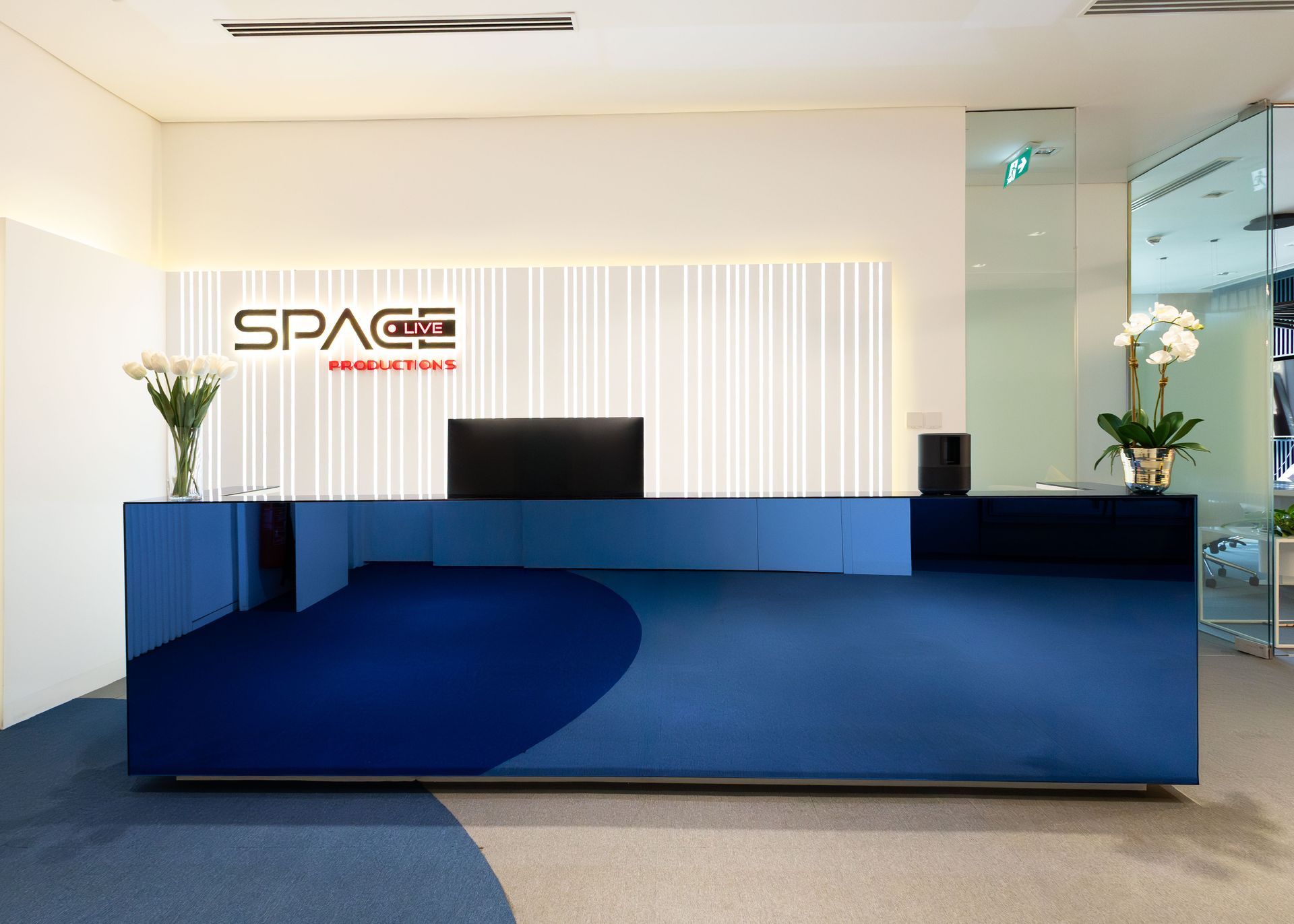A blue reception desk in a room with a sign that says space.