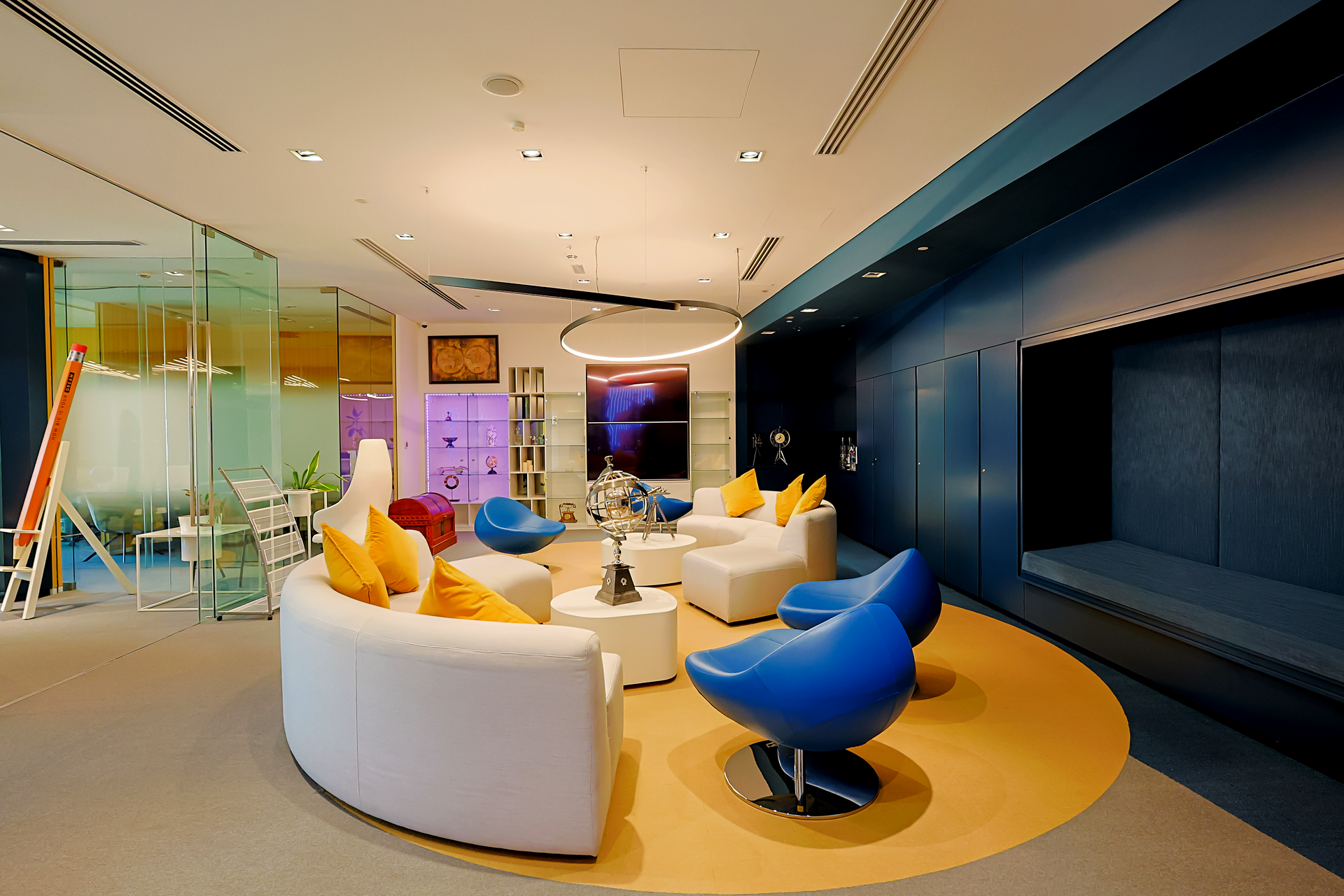 A living room with a round couch and blue chairs