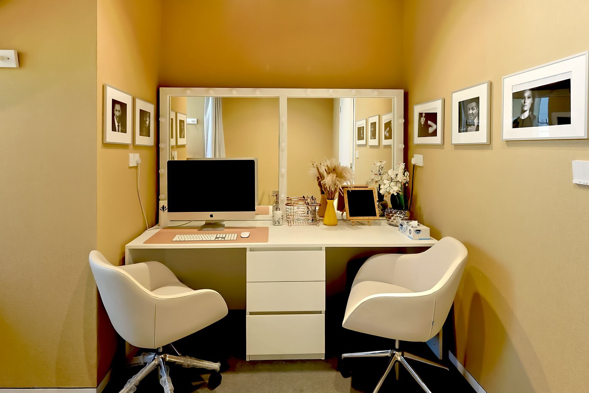 A room with two chairs and a desk with a computer on it