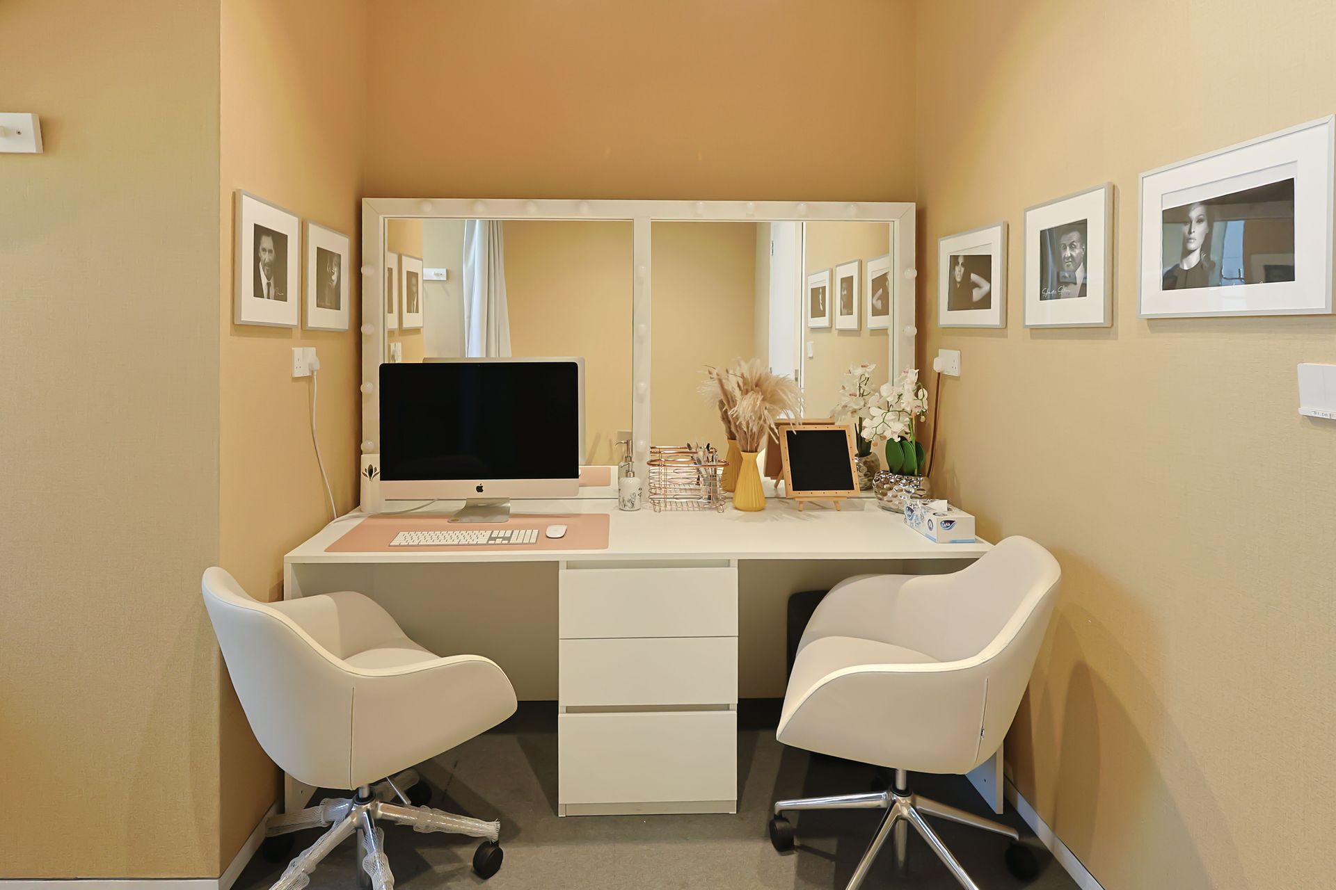 A room with two chairs and a desk with a computer on it.