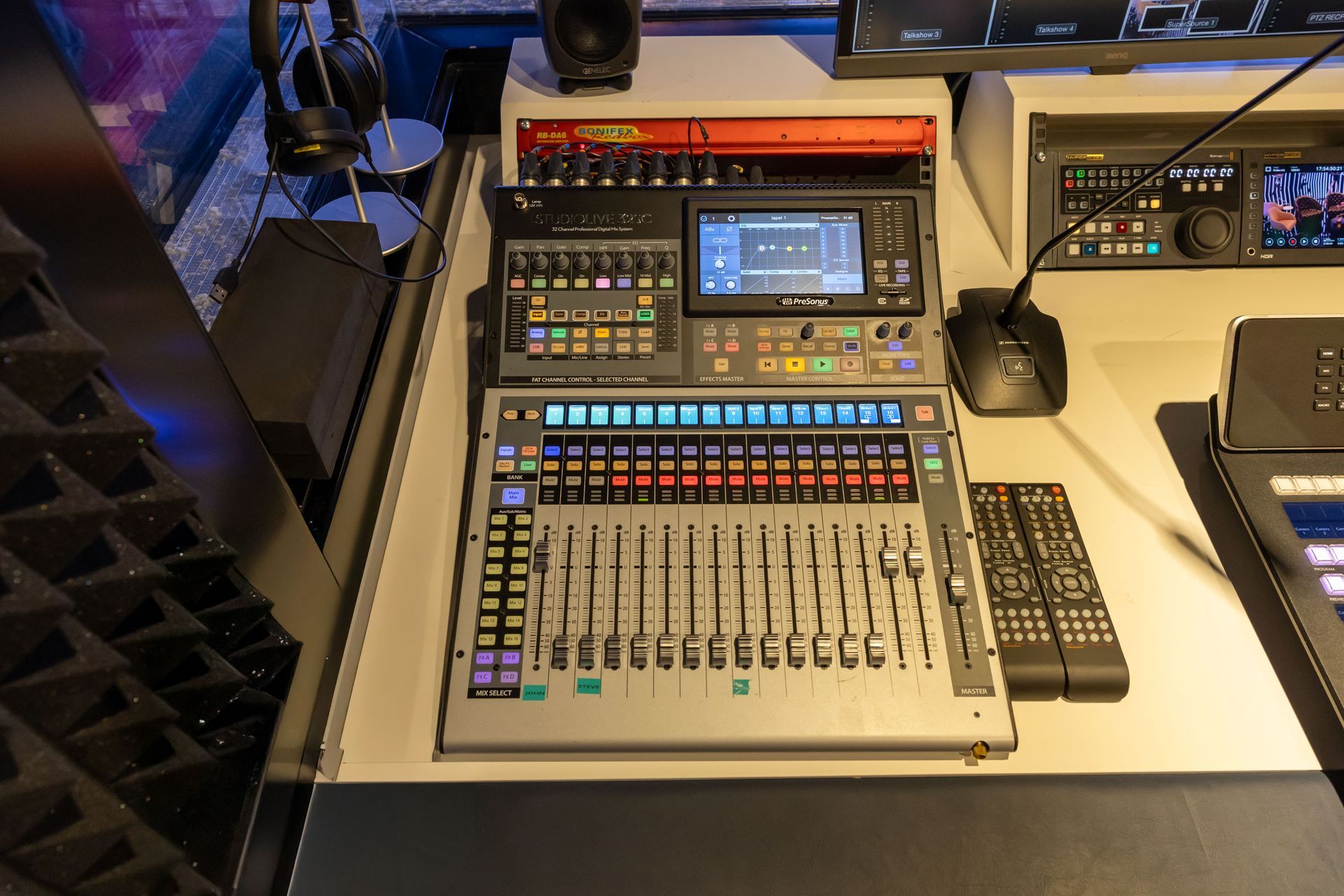 A mixer is sitting on top of a table next to a microphone.