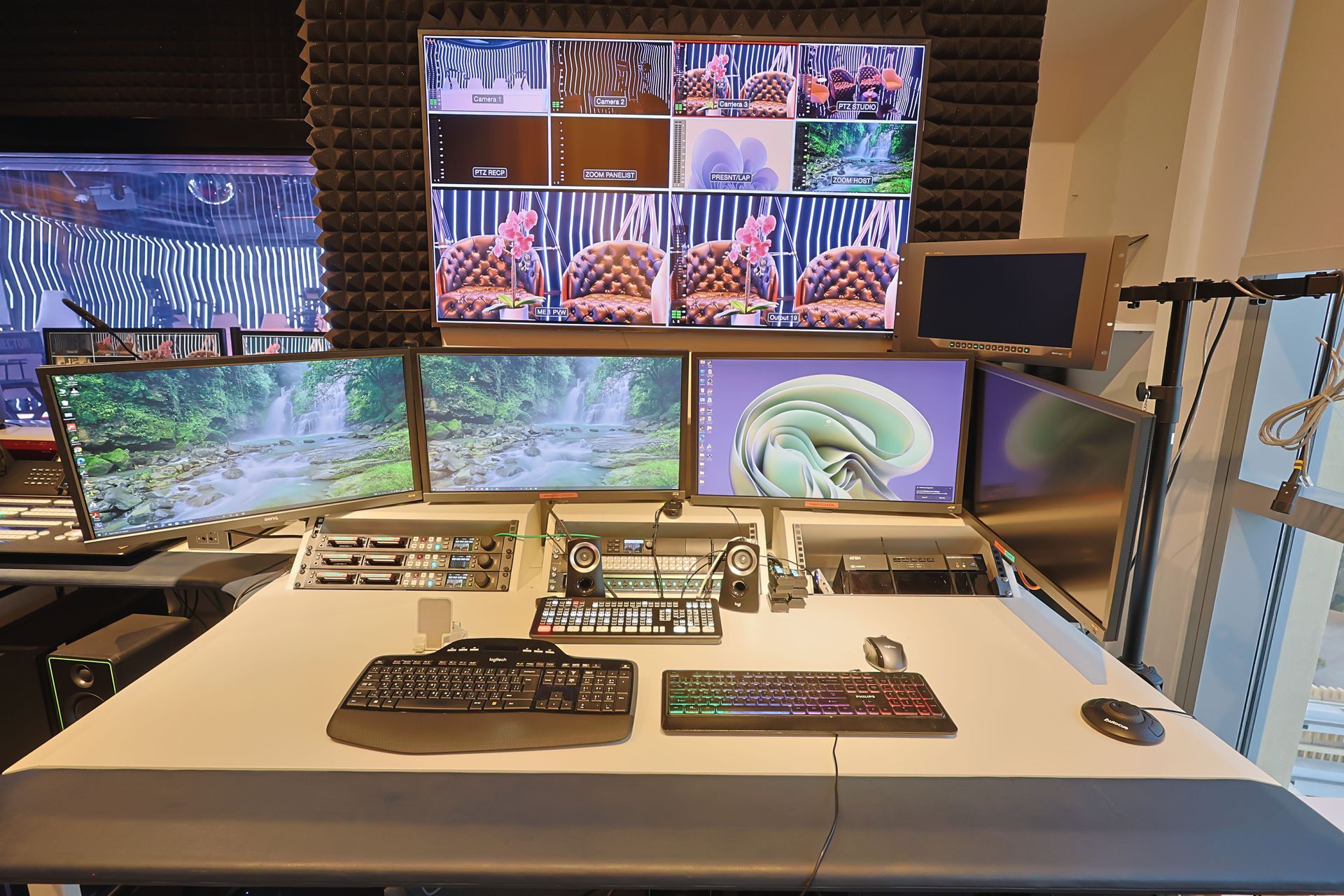 A computer desk with multiple monitors and a keyboard