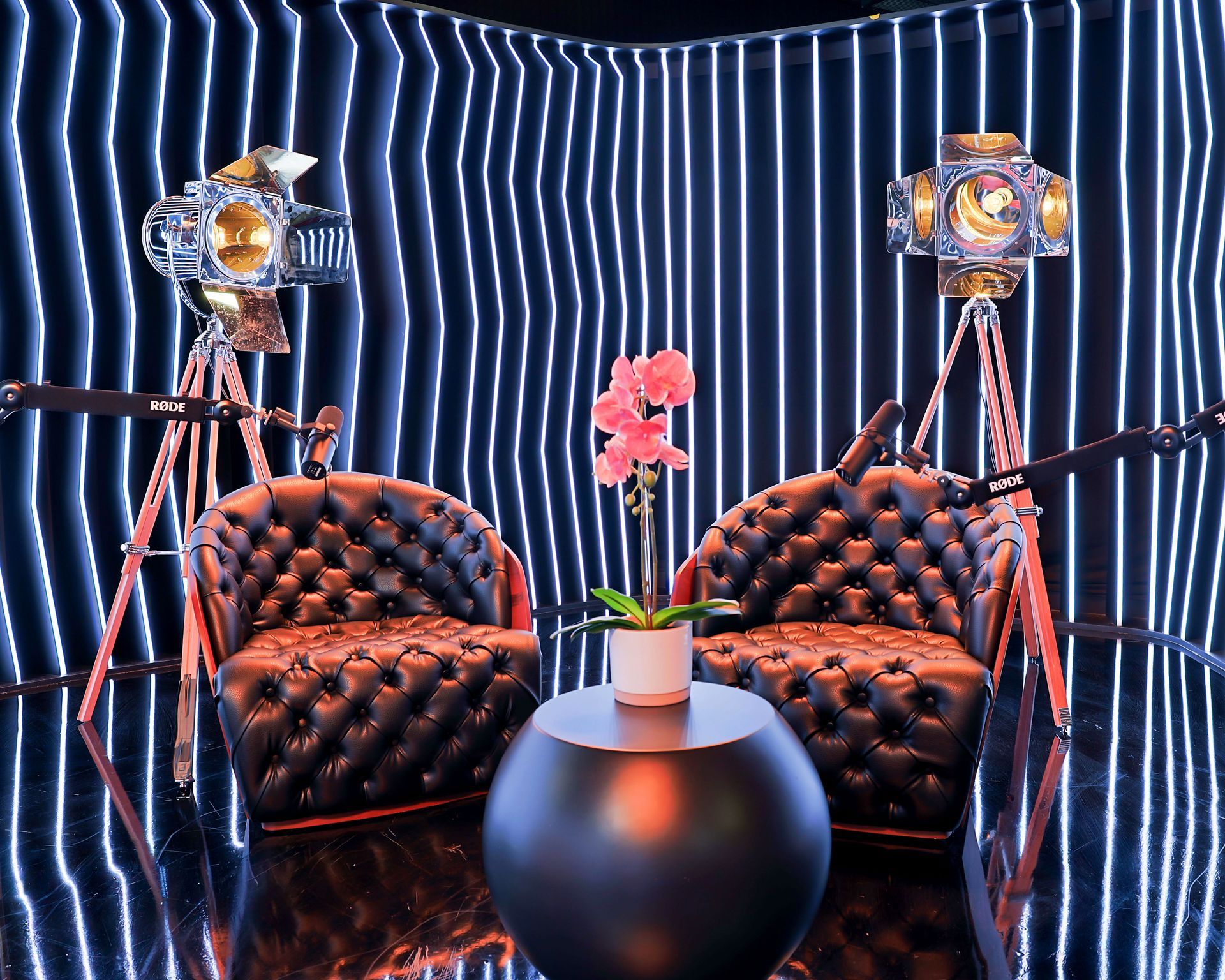 A room with two chairs and a table with a flower on it