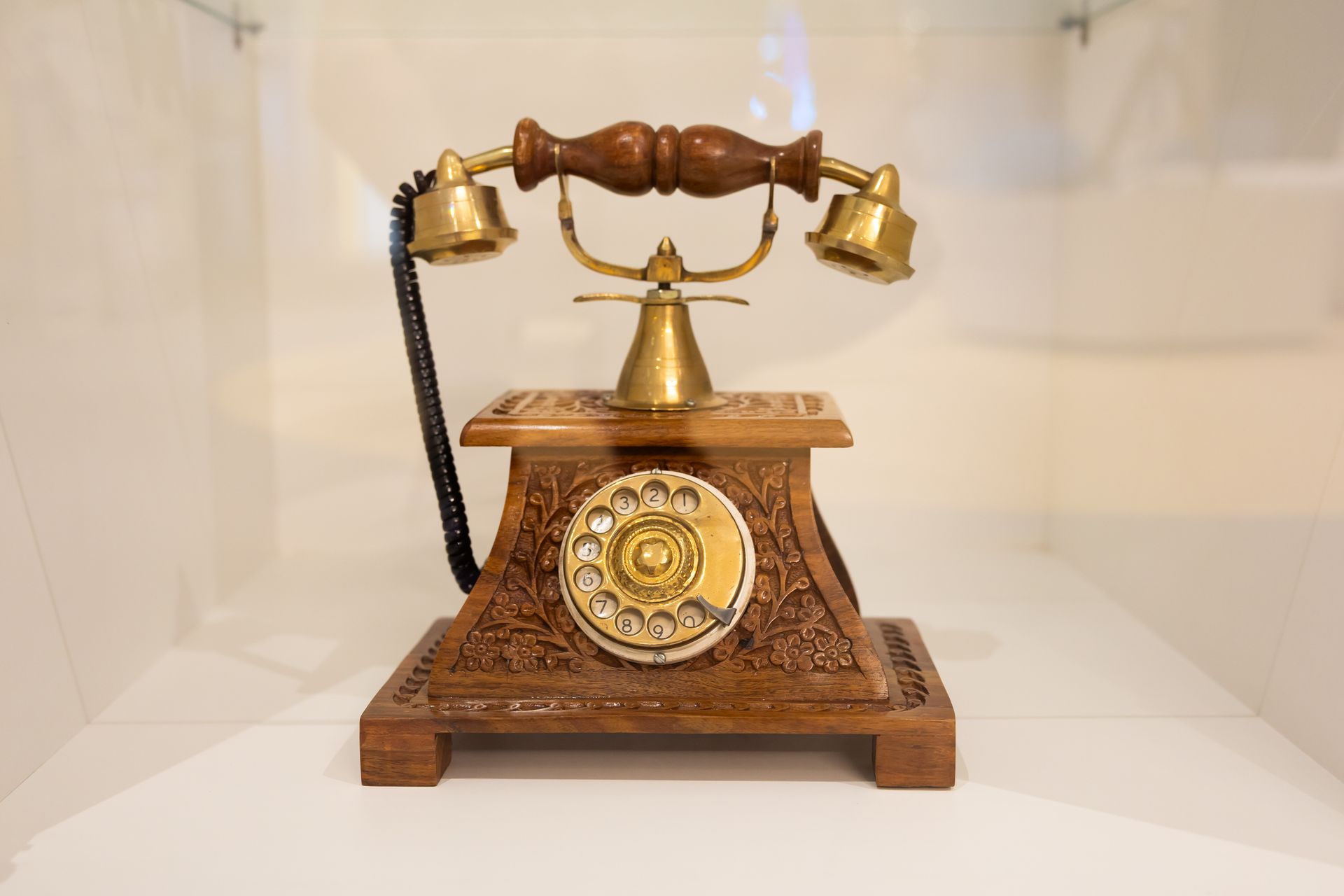 A black bowl is sitting on top of a glass shelf.