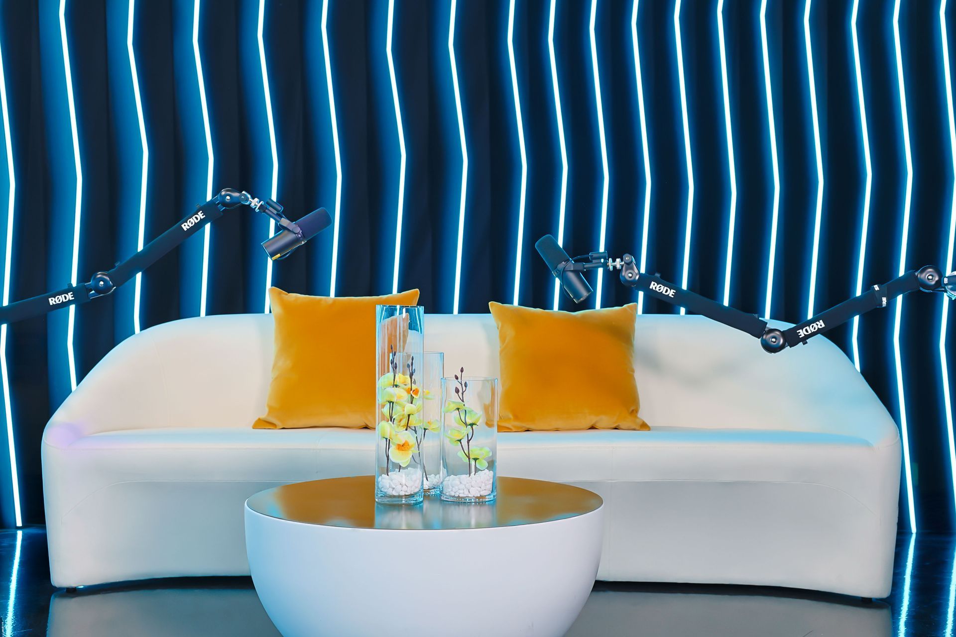 A white couch with yellow pillows and a white coffee table