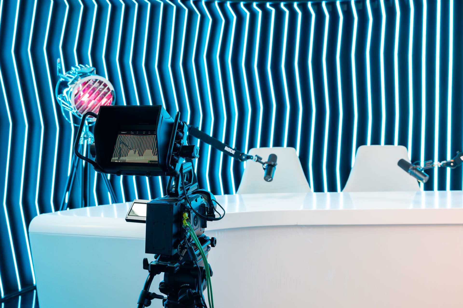 A camera is sitting on a table in front of a blue and white striped wall.
