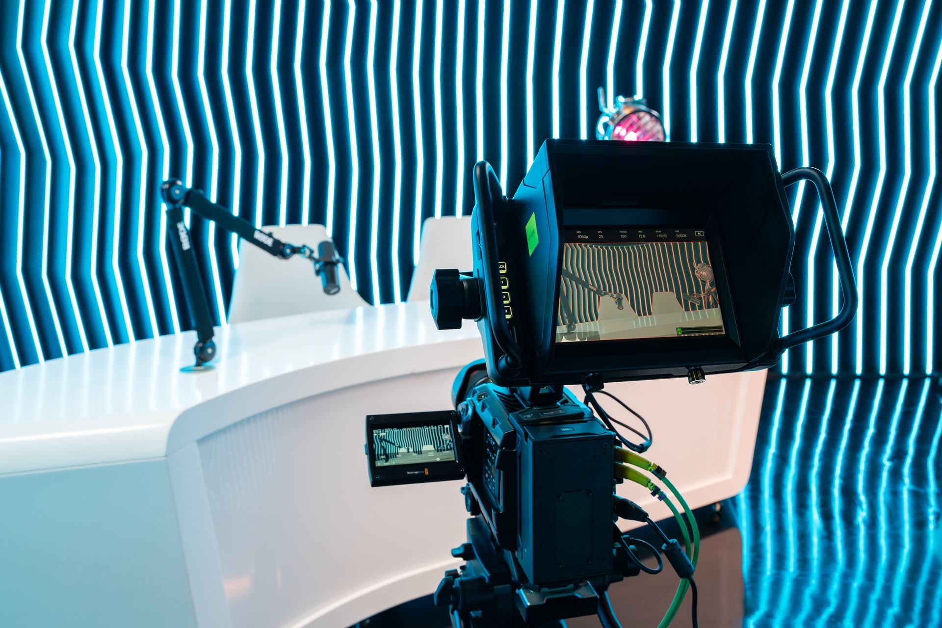 A camera is sitting on a table in front of a striped wall.
