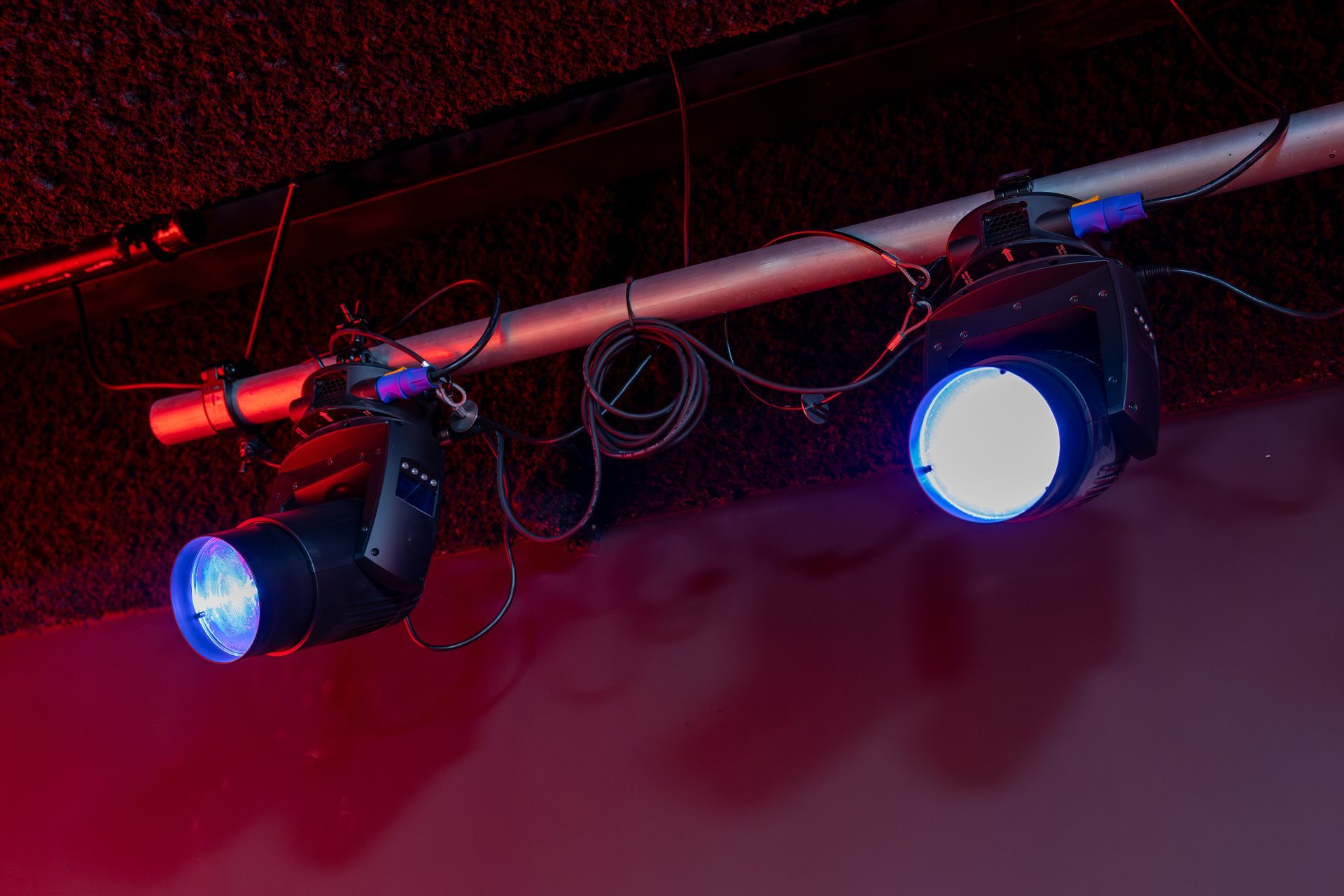 A couple of lights hanging from the ceiling in a dark room.