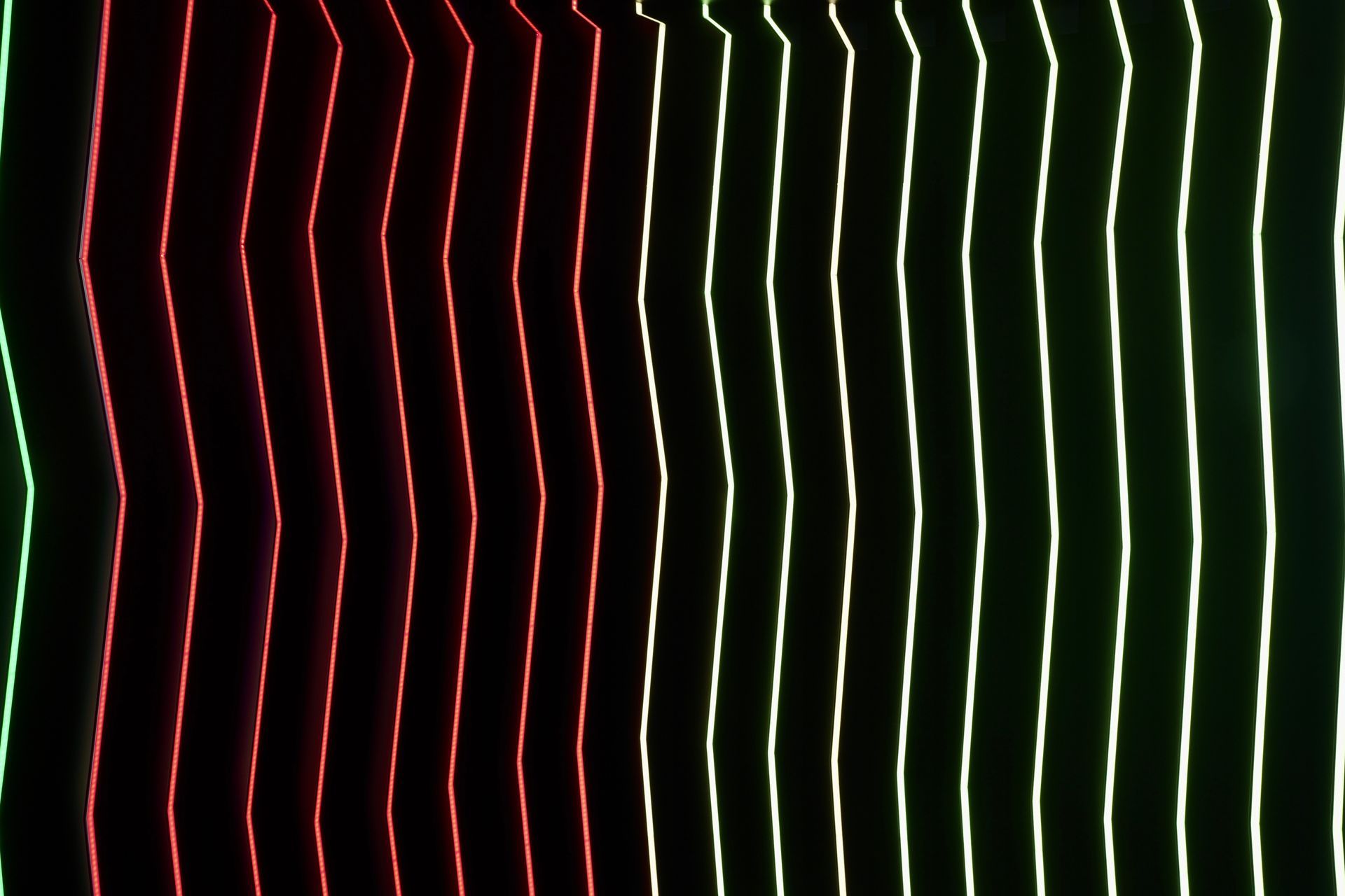 A close up of a red , green and white striped pattern on a black background.