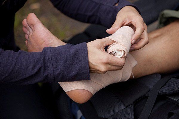 Man Putting Bandage on Ankle — Law Firm in Modesto, CA