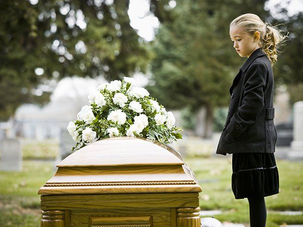 Girl Looking in Coffin at Cemetery — Law Firm in Modesto, CA