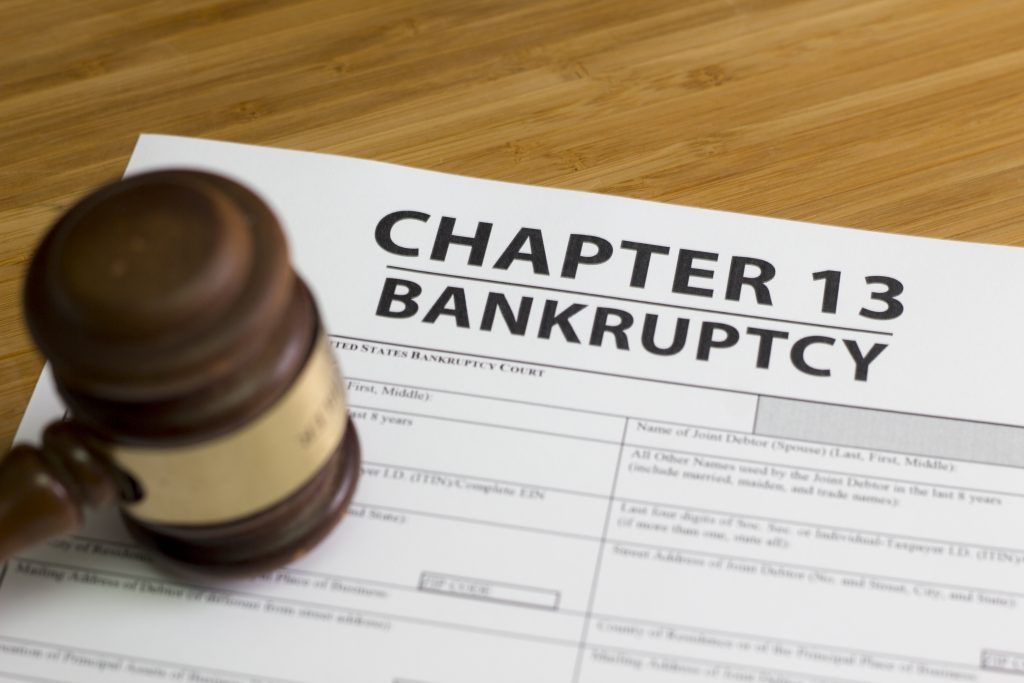 A judge 's gavel is sitting on top of a chapter 13 bankruptcy form.
