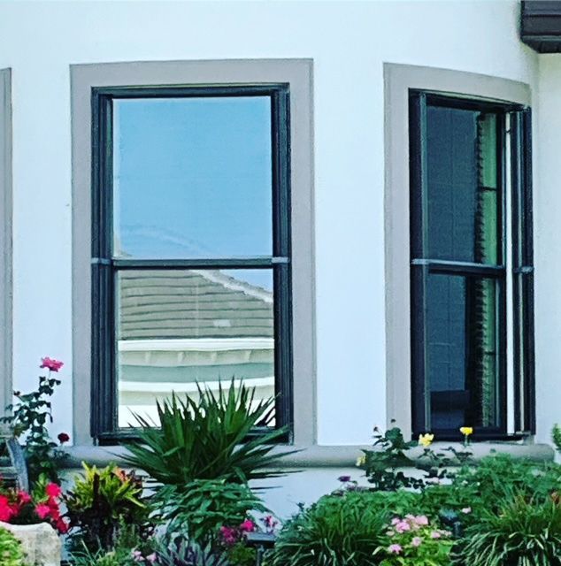 A house with a lot of windows and flowers in front of it