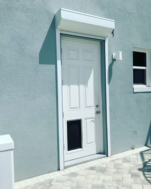 A white door with a cat door on the side of it