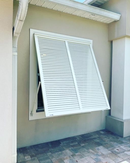 A white window with shutters on it is open