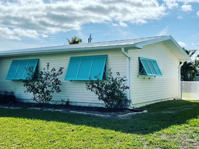 A white house with blue shutters on the windows