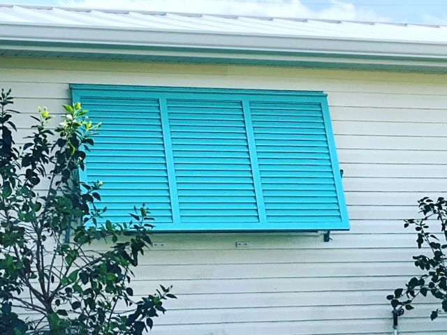 A white house with blue shutters on the windows