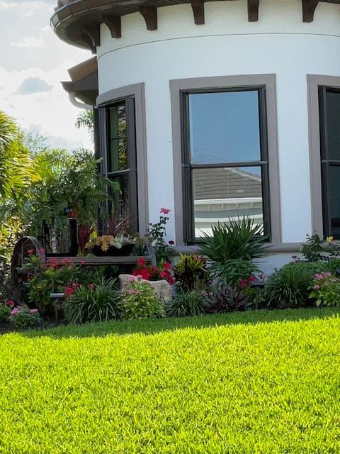 A white house with a lush green lawn in front of it