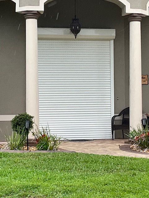 A white garage door is sitting on the side of a house