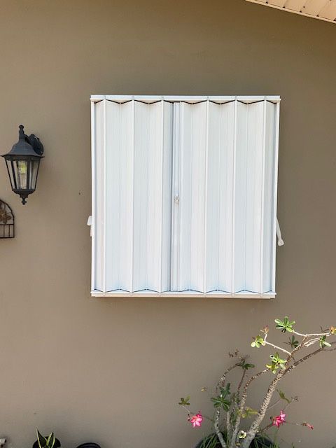 A brown wall with a white window and a lamp on it