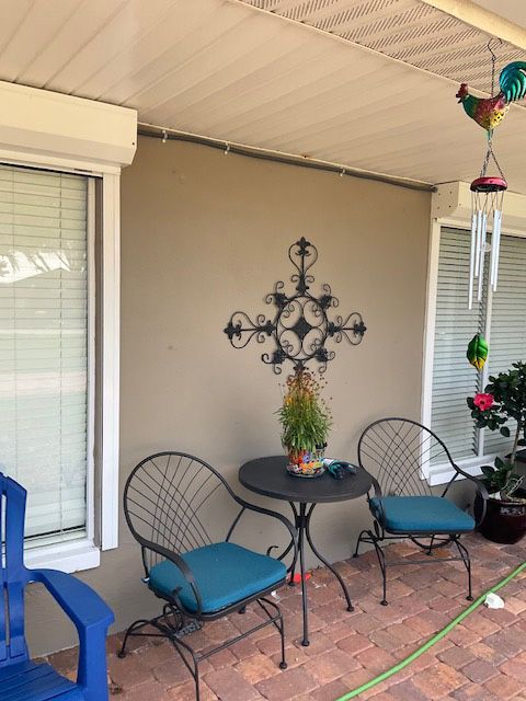 A patio with a table and chairs and a hose