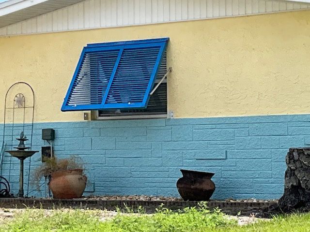 A house with a blue shutter on the window