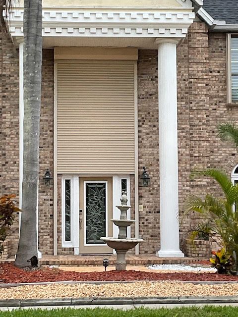 A large brick house with a fountain in front of it