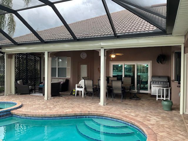 There is a large swimming pool in the backyard of a house