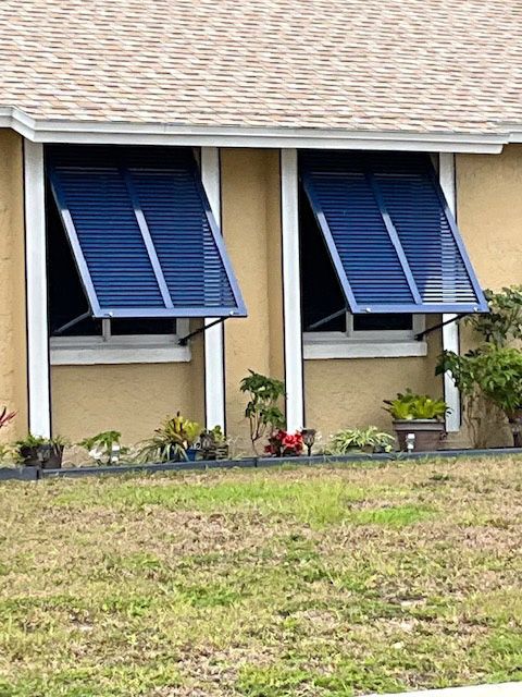 A house with two windows with blue shutters on them