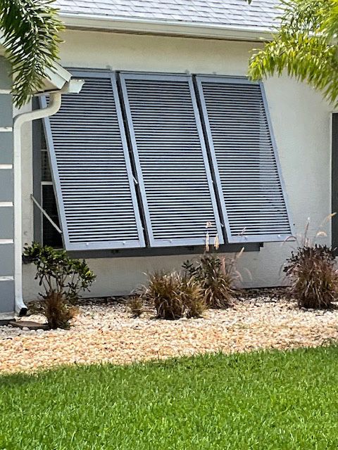A house with shutters on the windows and a gutter on the side of it