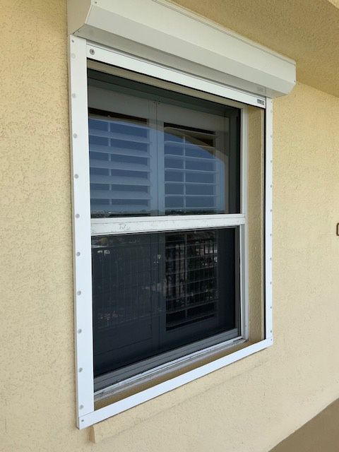 A window with a white frame and shutters on it