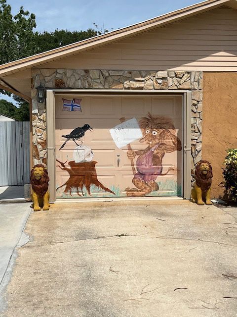 A garage door with a painting of a lion and a bird on it