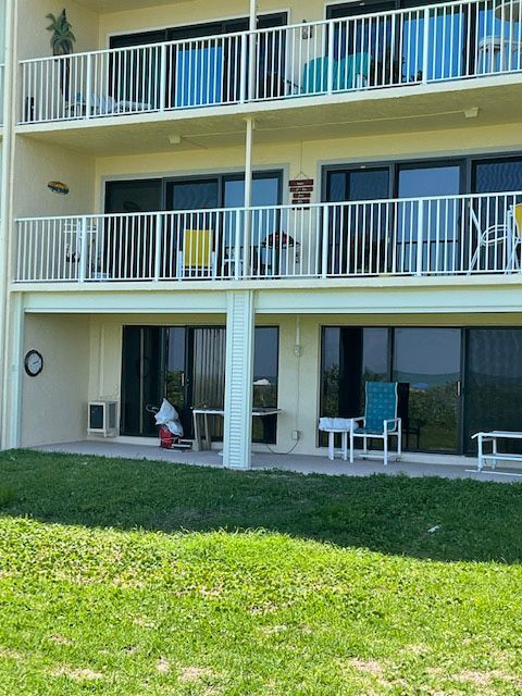 A large building with a balcony and a lawn in front of it