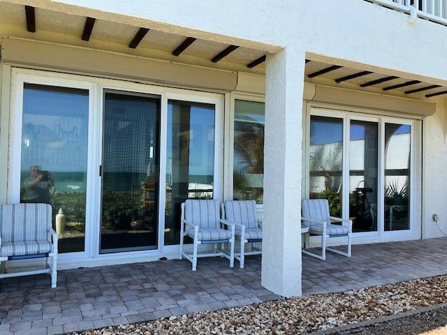 A white house with sliding glass doors and chairs
