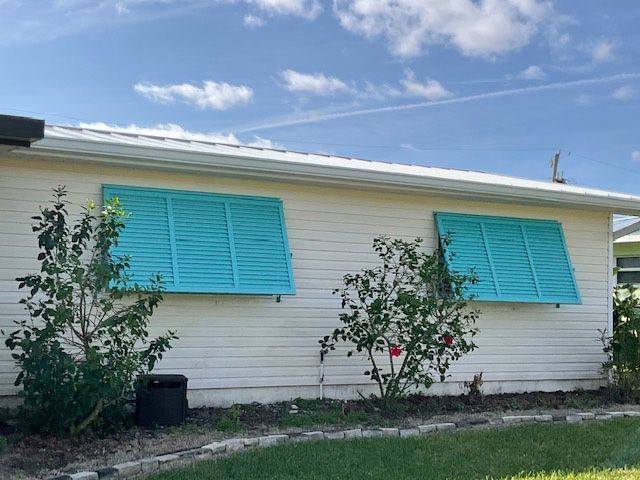 A white house with blue shutters on the windows