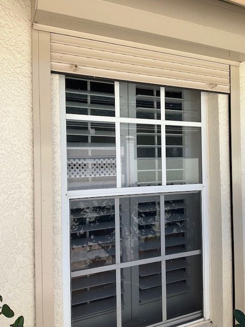 A window with shutters on it and a white frame