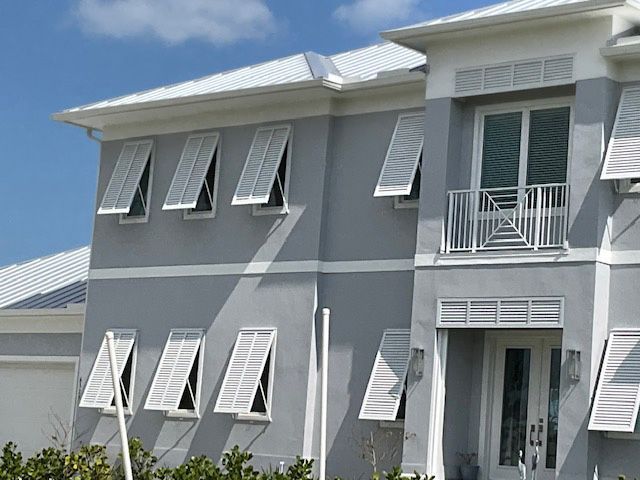 A gray house with white shutters on the windows