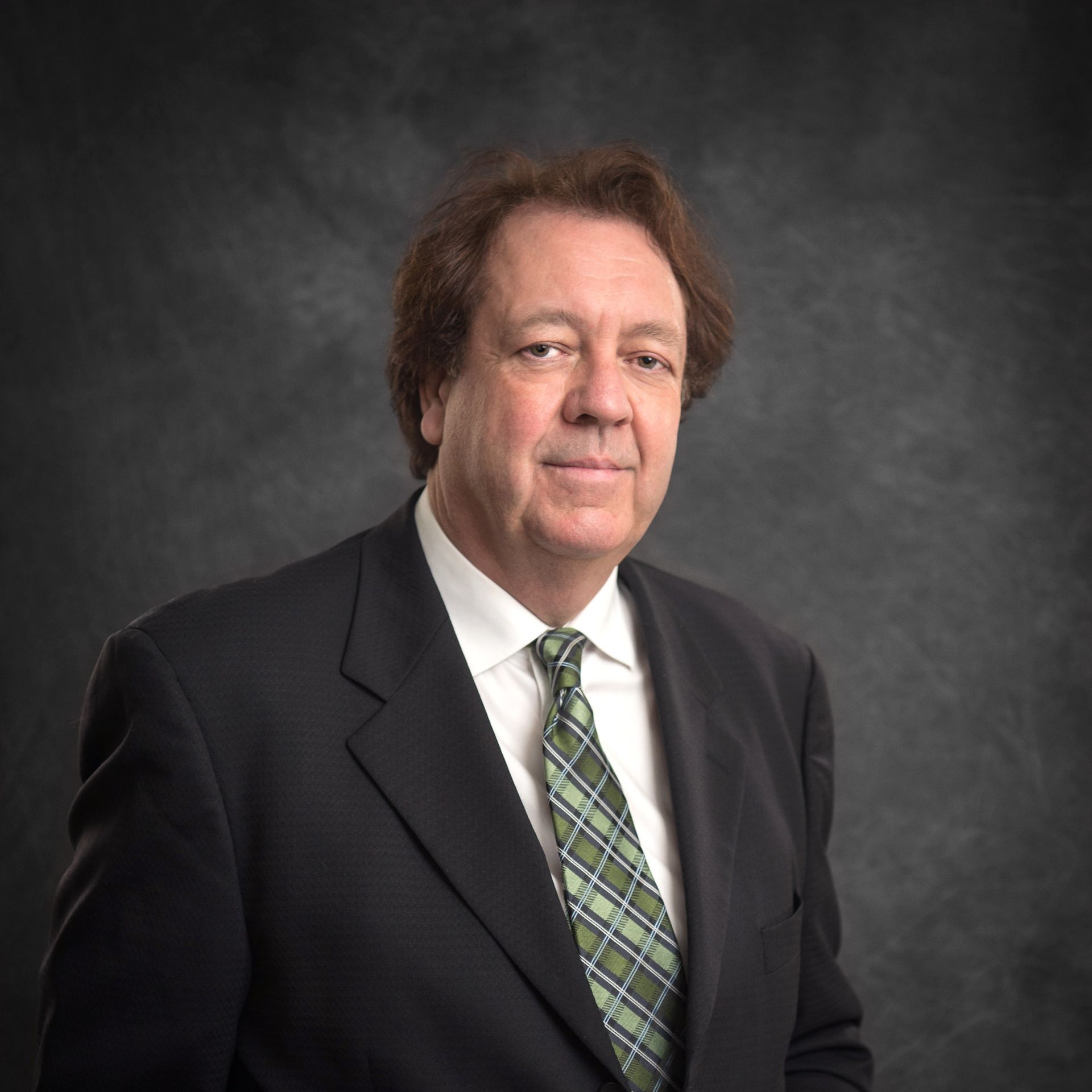 A man in a white shirt and tie with his arms crossed