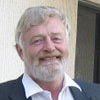 A man with a beard and a suit is smiling for the camera.