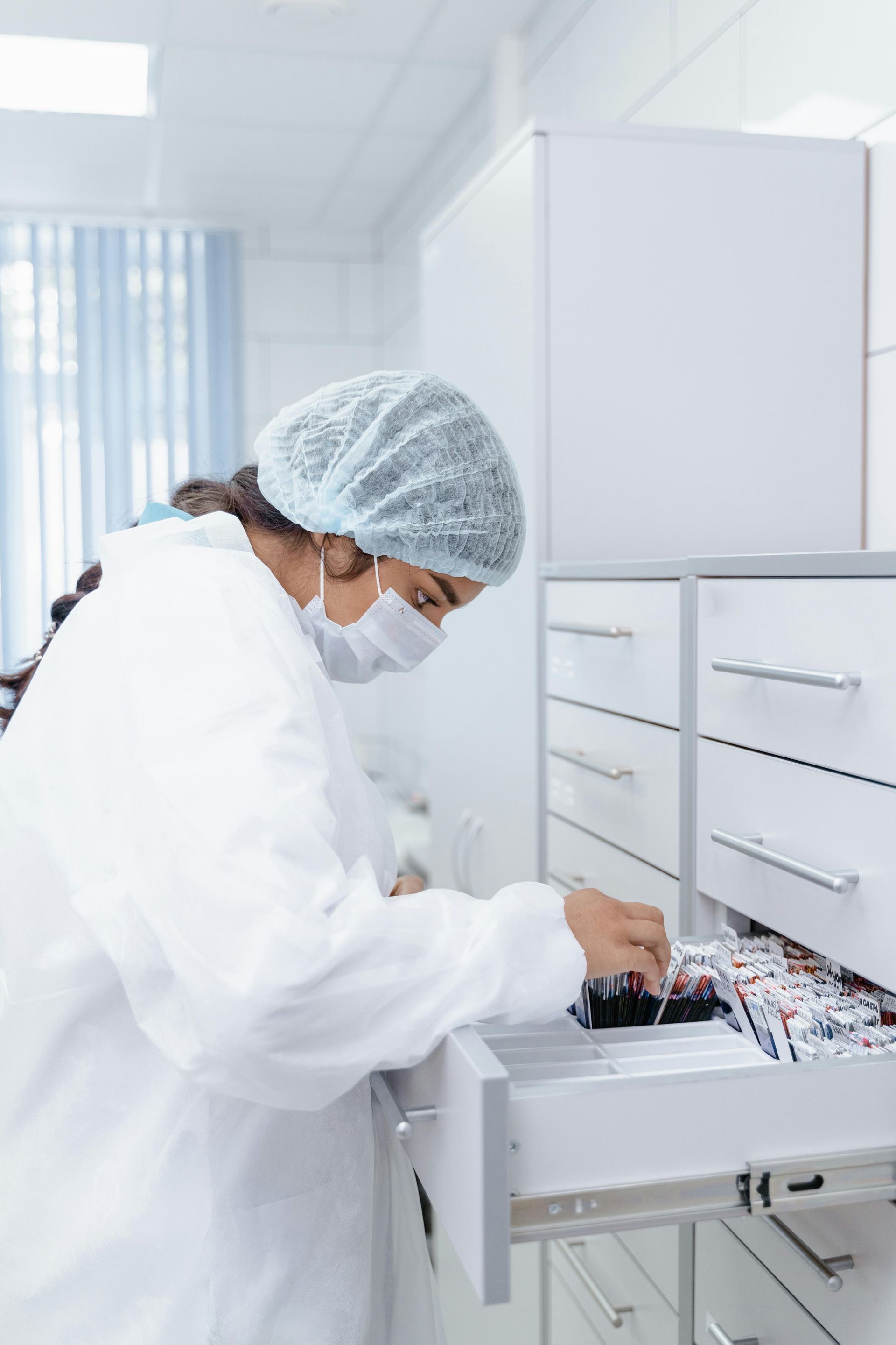 A pharmacist is looking through a drawer. 