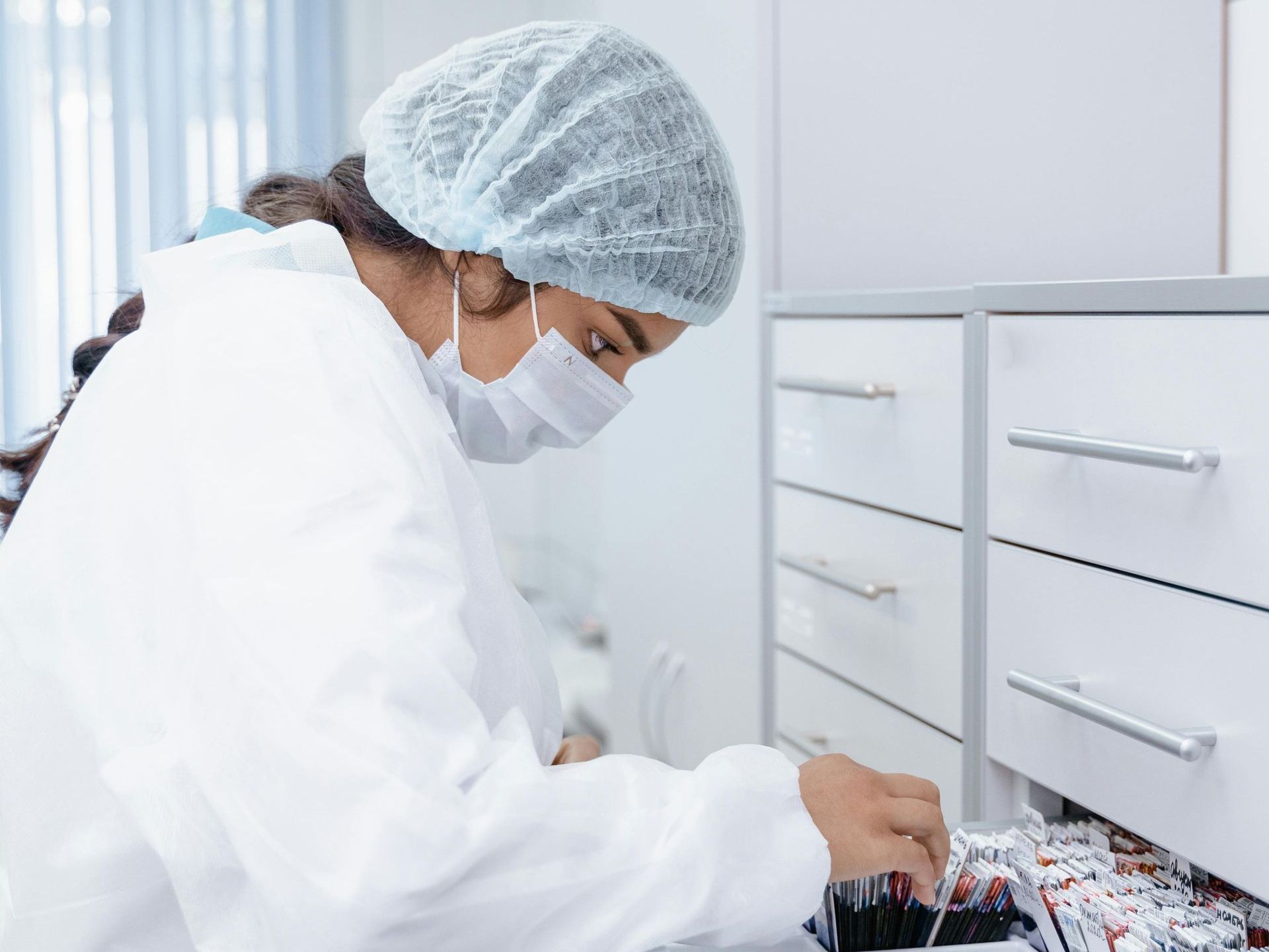 A pharmacist is looking through a drawer.