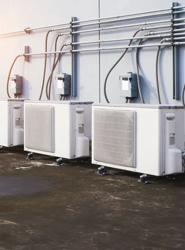 A furnace is sitting in a corner of a room.