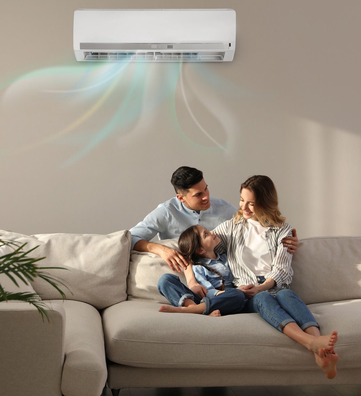 A family is sitting on a couch under an air conditioner.
