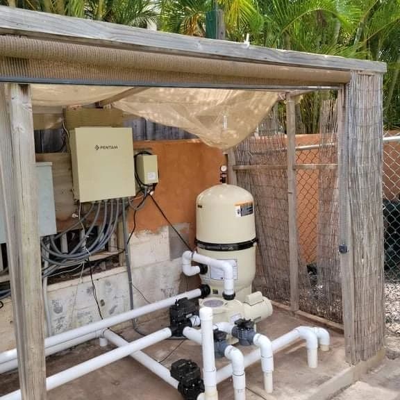 Pool equipment shed with pump, filter, and electrical components.