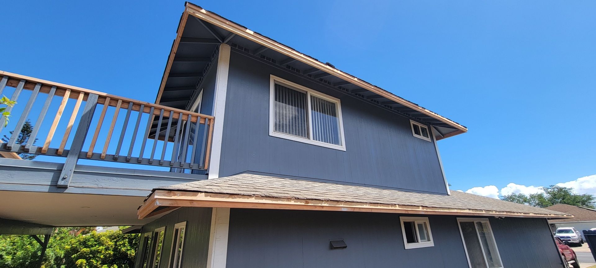Blue house with a deck on a bright sunny day.
