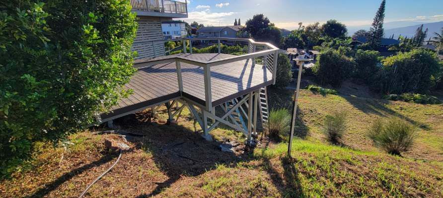 A wooden viewing platform on a hillside overlooking a lush landscape.