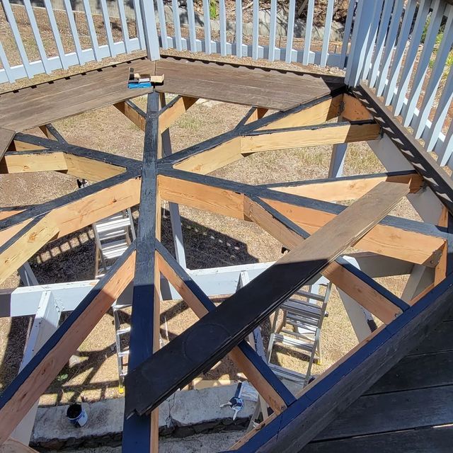 Overhead view of a wooden deck framing project with beams and railings in progress