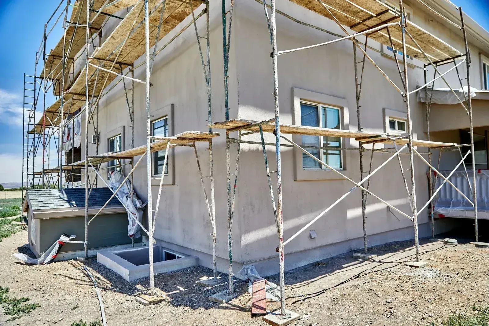 House under construction with scaffolding and unfinished exterior walls
